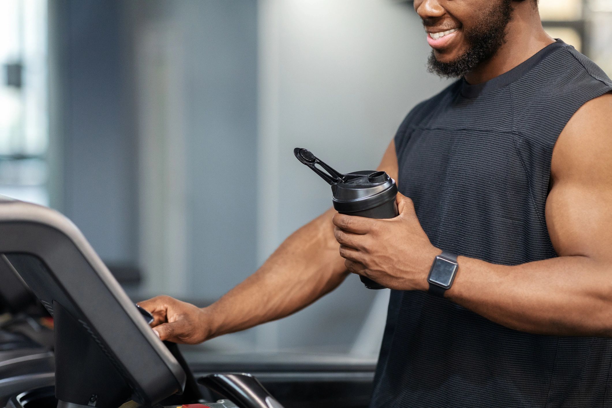 Person on treadmill holding a protein drink bottle