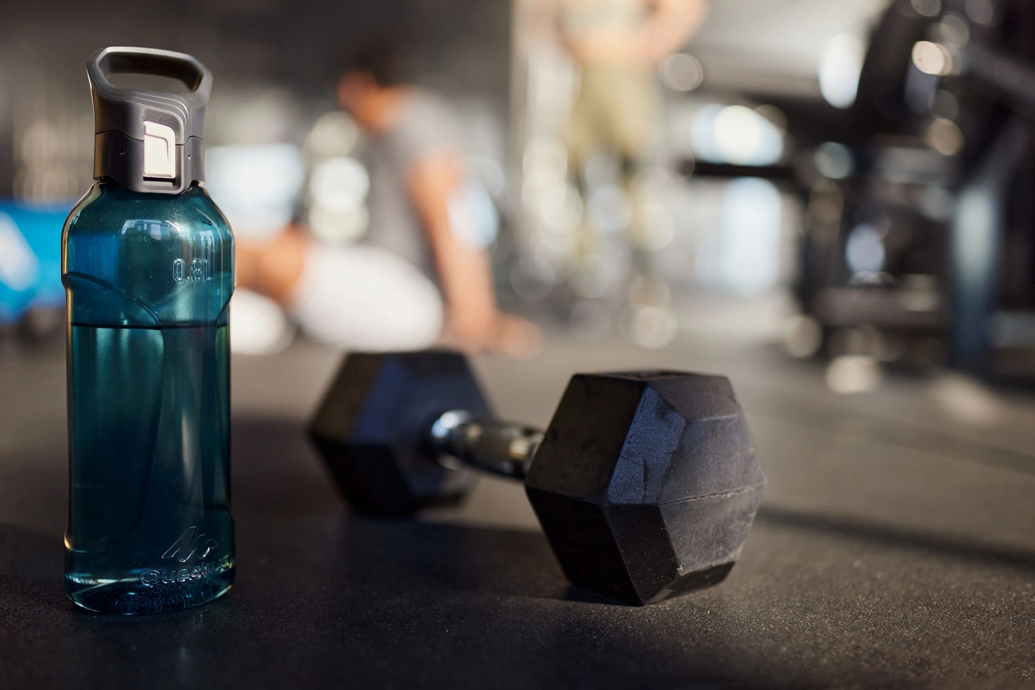 Water bottle and dumbbell on a gym floor